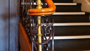 Un escalier avec une main courante en bois et des balustres en métal.