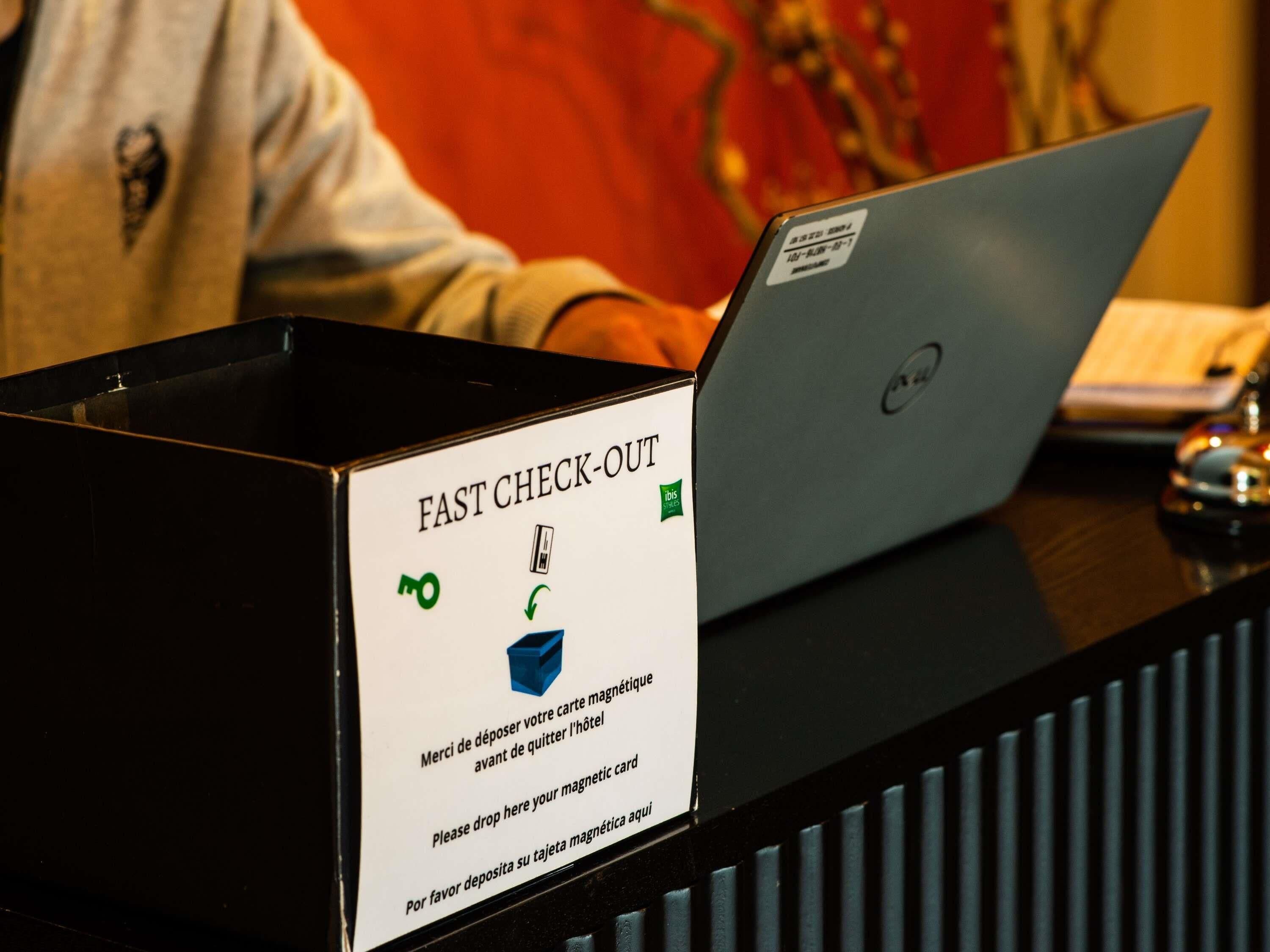 A check-out counter with a sign instructing to deposit magnetic cards.