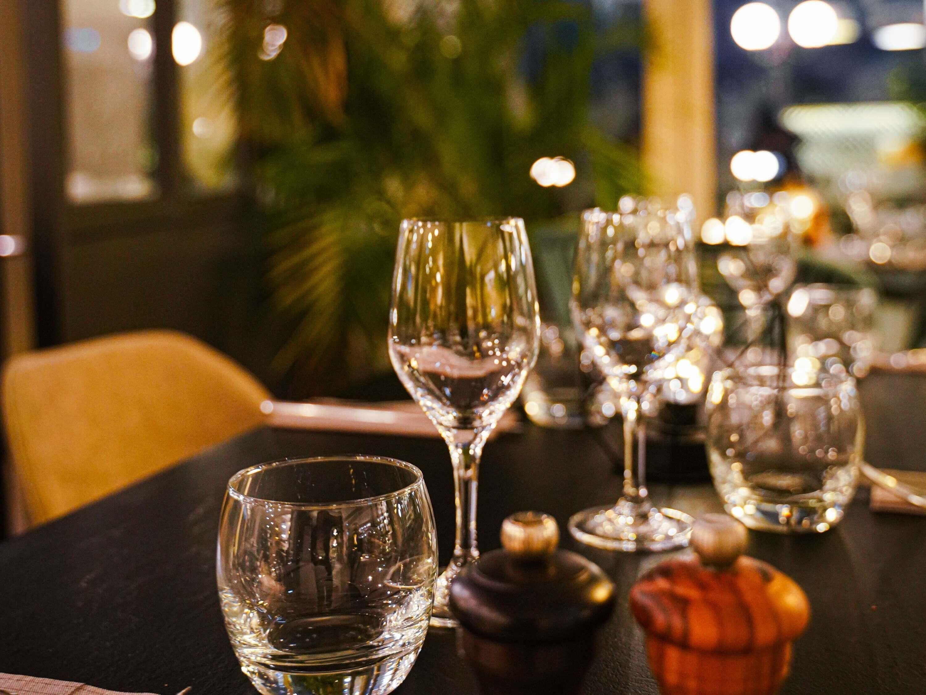 Ein Tisch mit mehreren Weingläsern und einer Flasche, vermutlich in einem Restaurant.
