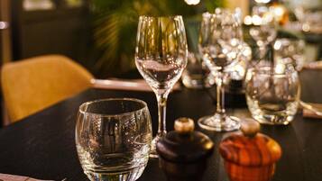 A table with multiple wine glasses and a bottle, likely in a restaurant setting.