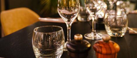 Una mesa con varias copas de vino y una botella, probablemente en un restaurante.