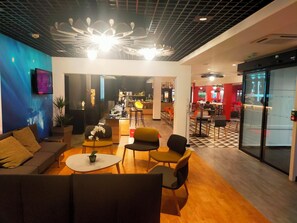 Ein modernes Interieur mit einer Sitzecke, einer Bar und einer Küche im Hintergrund.