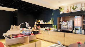 A modern kitchen with wooden cabinets, a built-in coffee machine, and a variety of kitchen appliances. - ibis Strasbourg Sud La Vigie (Ostwald)