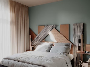 A bedroom with a bed, curtains, and a wall with geometric patterns.