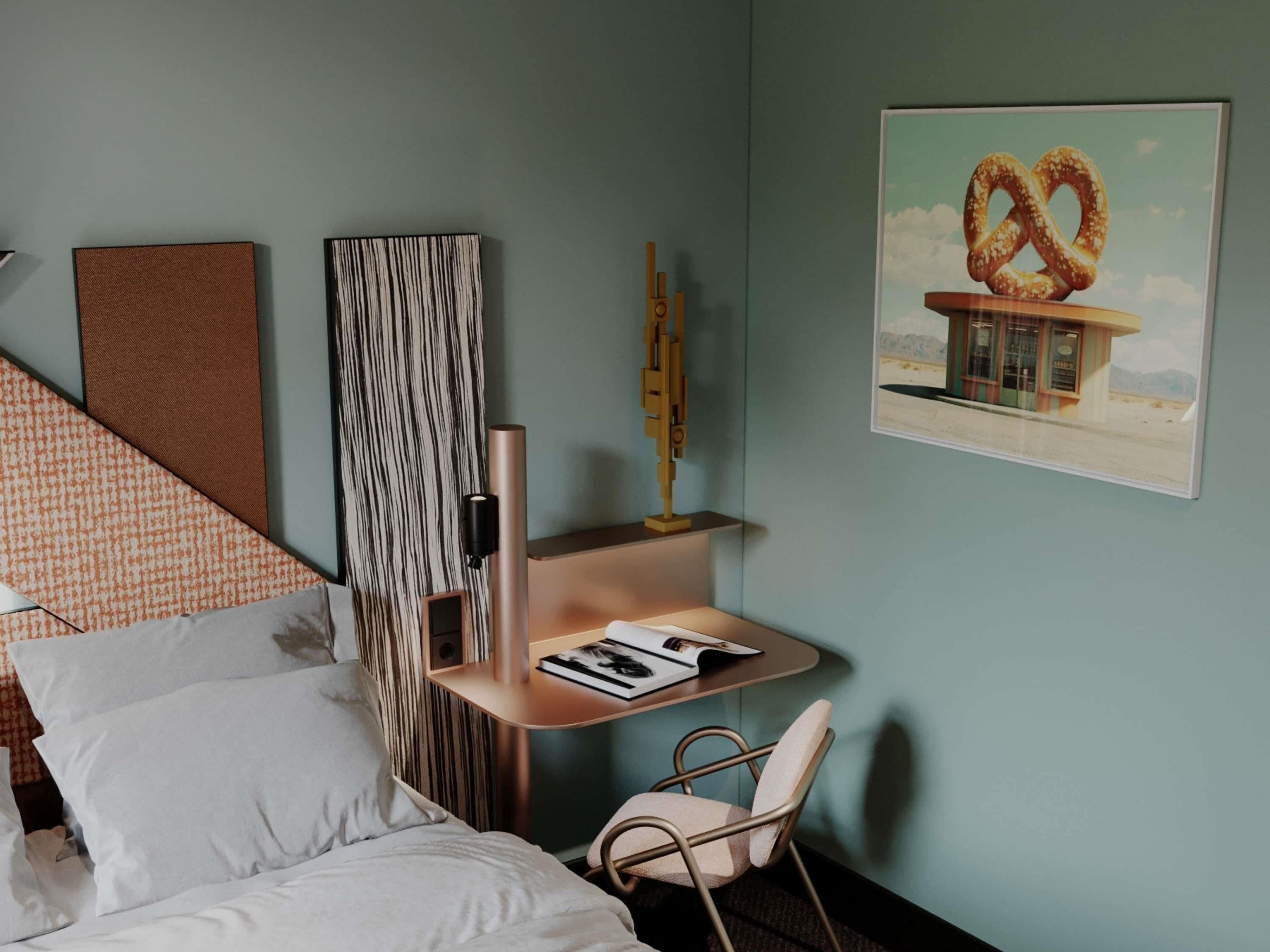 A bedroom with a bed, a small desk with a chair, a bookshelf, and a wall-mounted artwork of a pretzel.