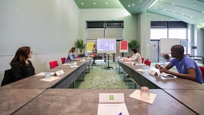 A conference room with a long table, name cards, and a presentation screen.
