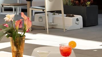 A modern outdoor seating area with a table, chairs, and a potted plant.