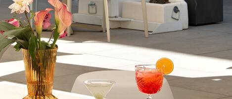 A modern outdoor seating area with a table, chairs, and a potted plant.