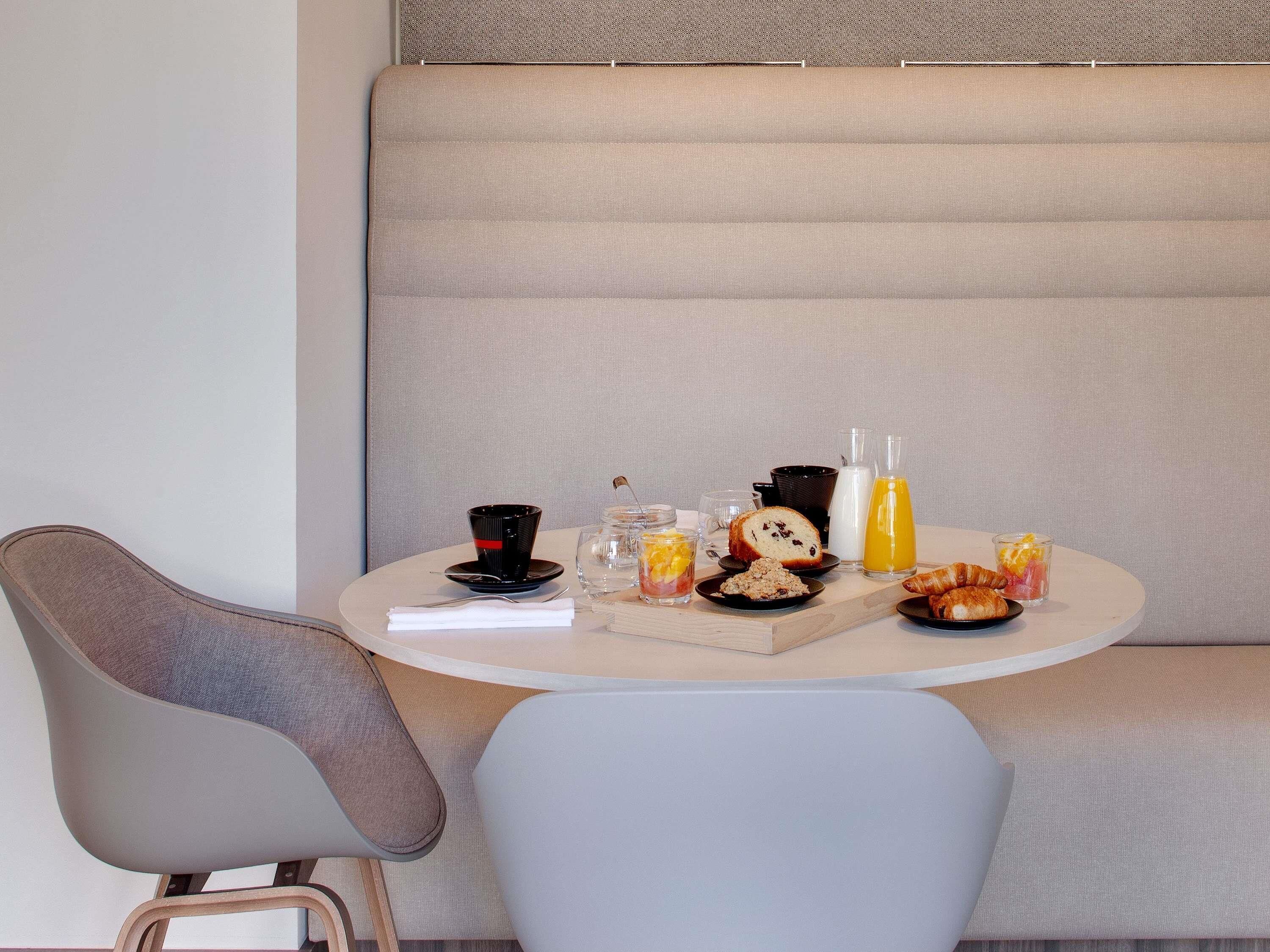 A breakfast setup with a table, chairs, and a sofa.