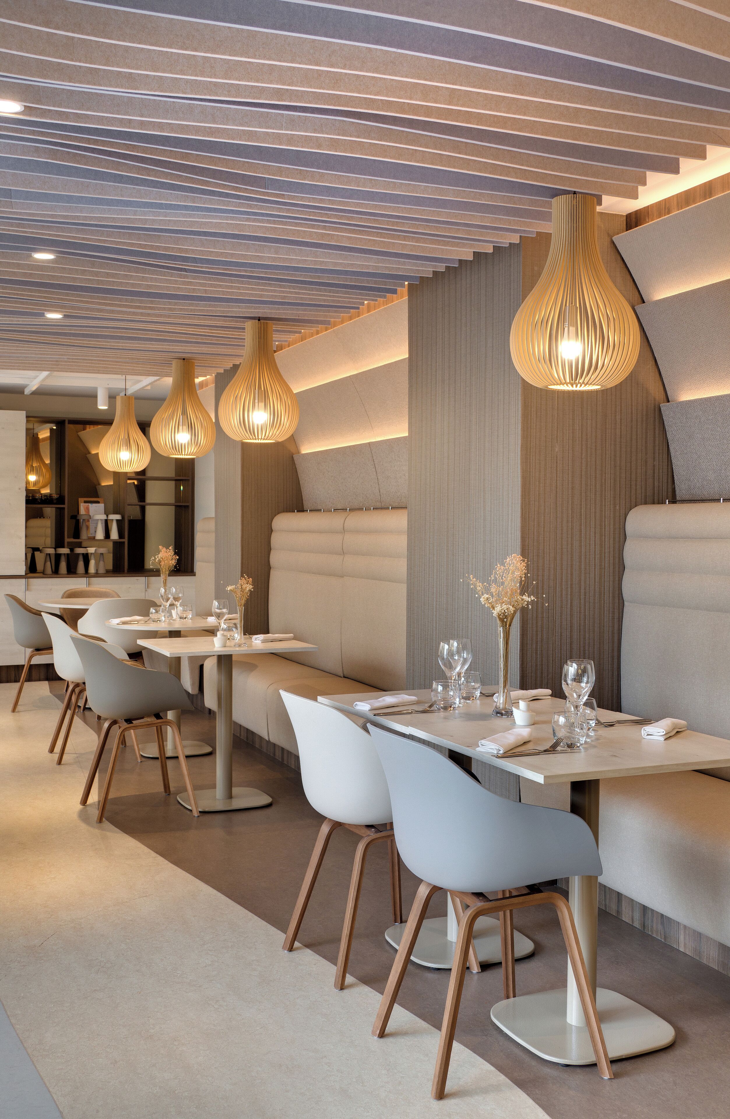 A modern restaurant interior with sleek, contemporary furniture and stylish pendant lighting.