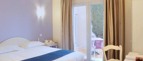 Una habitación de hotel con cama, escritorio, silla y vistas al exterior.
