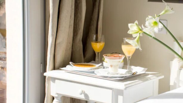 Una mesa de desayuno ordenada con un tazón de cereales, un vaso de jugo de naranja y un vaso de leche.