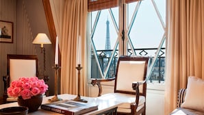 A room with a view of the Eiffel Tower, a table with a vase of pink roses, a lamp, and a book titled "Luxury Houses City". - Le Dokhan’s Paris Arc de Triomphe, a Tribute Portfolio Hotel (Paris)