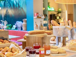 Een bakkerij toonbank met diverse gebakjes, brood en potten jam.