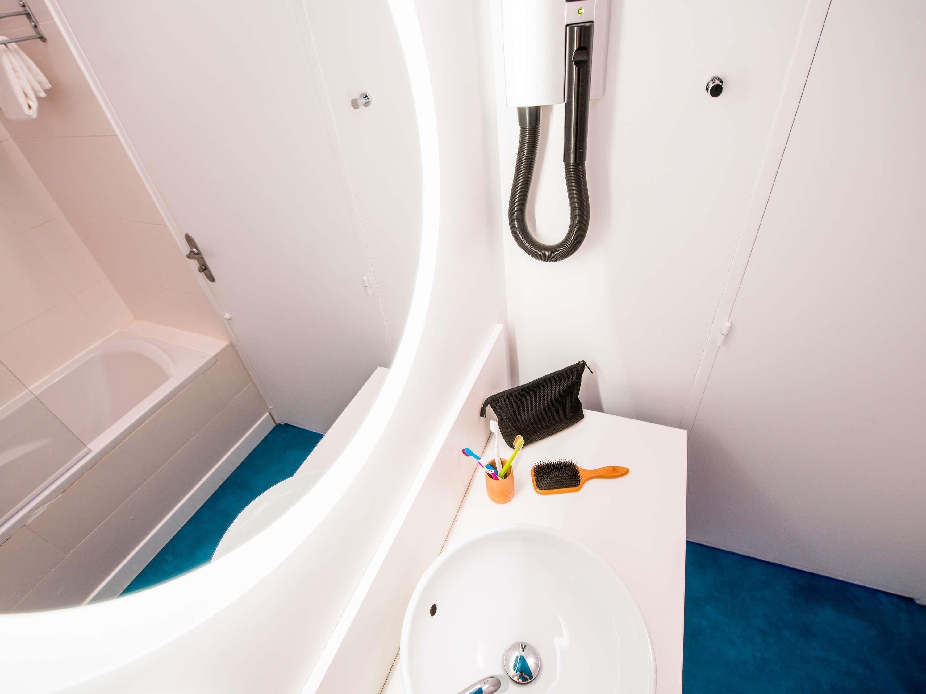 Een moderne badkamer met een wit bad, een wastafel en een douche.