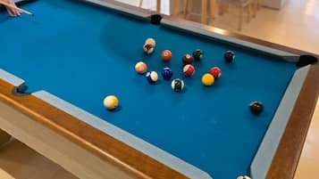 Una mesa de billar con bolas de colores variadas esparcidas.