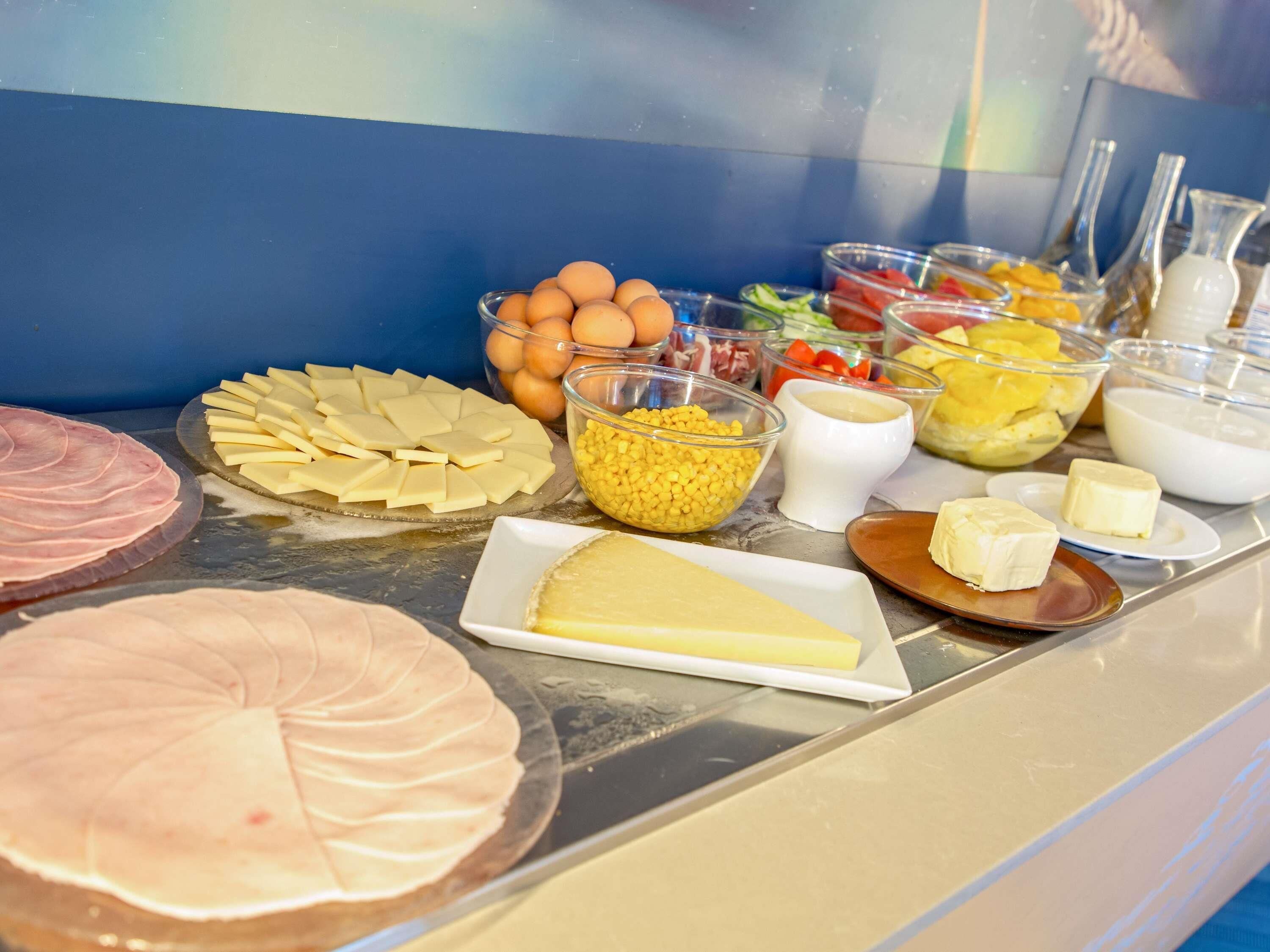 Un buffet proposant une variété d’aliments, notamment du fromage, des œufs et des fruits.