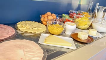 Un buffet proposant une variété d’aliments, notamment du fromage, des œufs et des fruits.