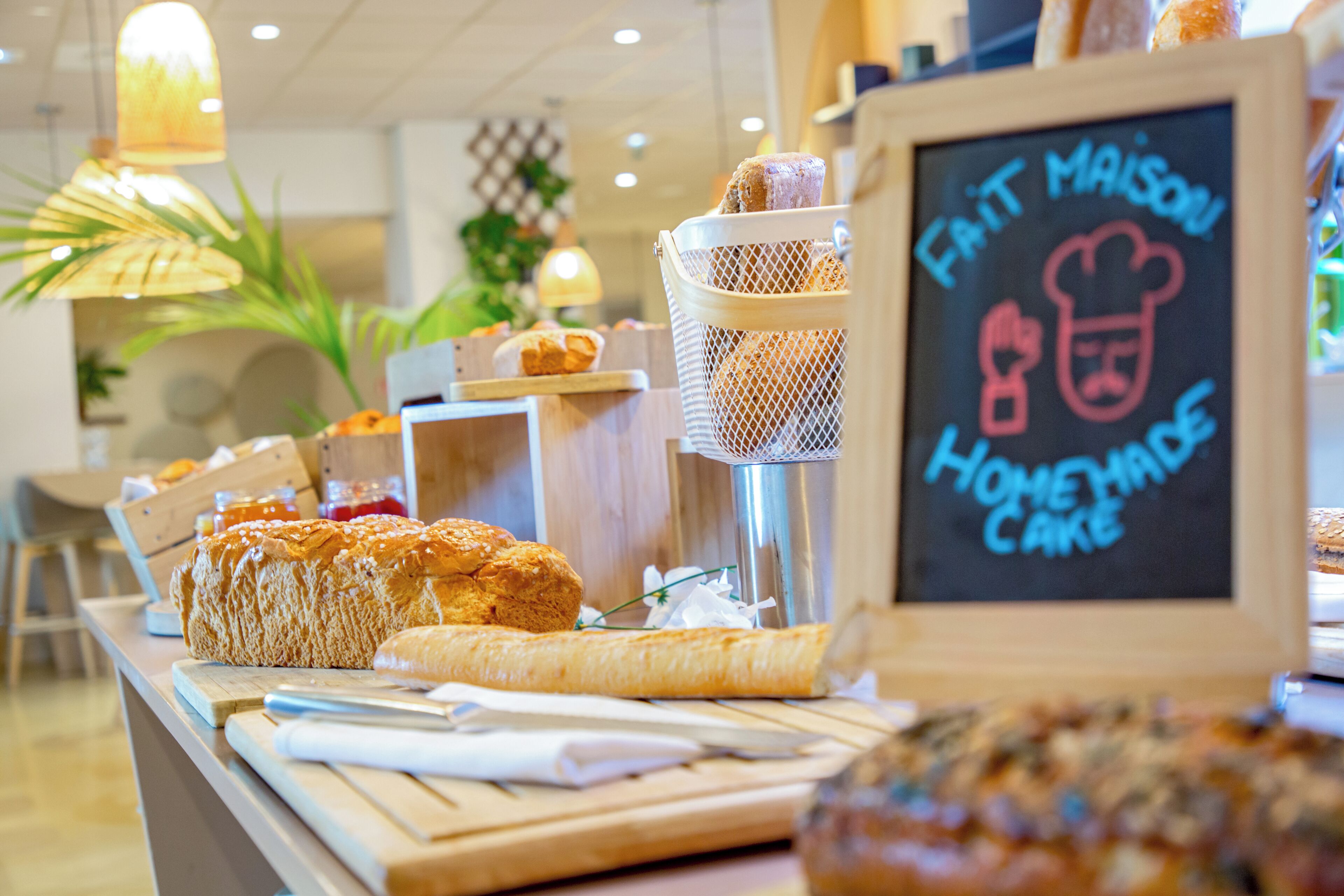 A bakery display with various baked goods and a chalkboard sign advertising homemade cakes.