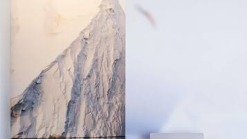 Une grande sculpture de glace sur laquelle se tient une personne.