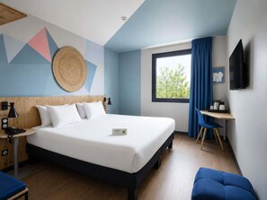 Une chambre dâhĂŽtel moderne Ă©quipĂ©e dâun lit, dâune table de chevet, dâune lampe et dâun bureau avec une chaise.