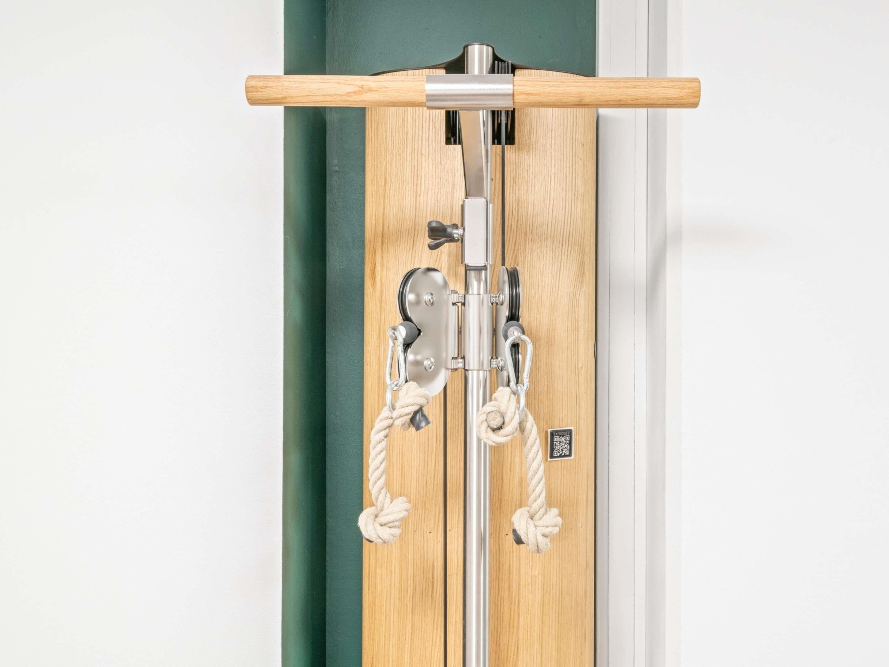 A wooden door with a metal handle and a rope tied to the handle.