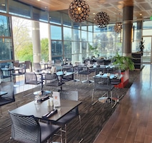 Un comedor interior amplio con techos altos, ventanas grandes y mobiliario moderno.