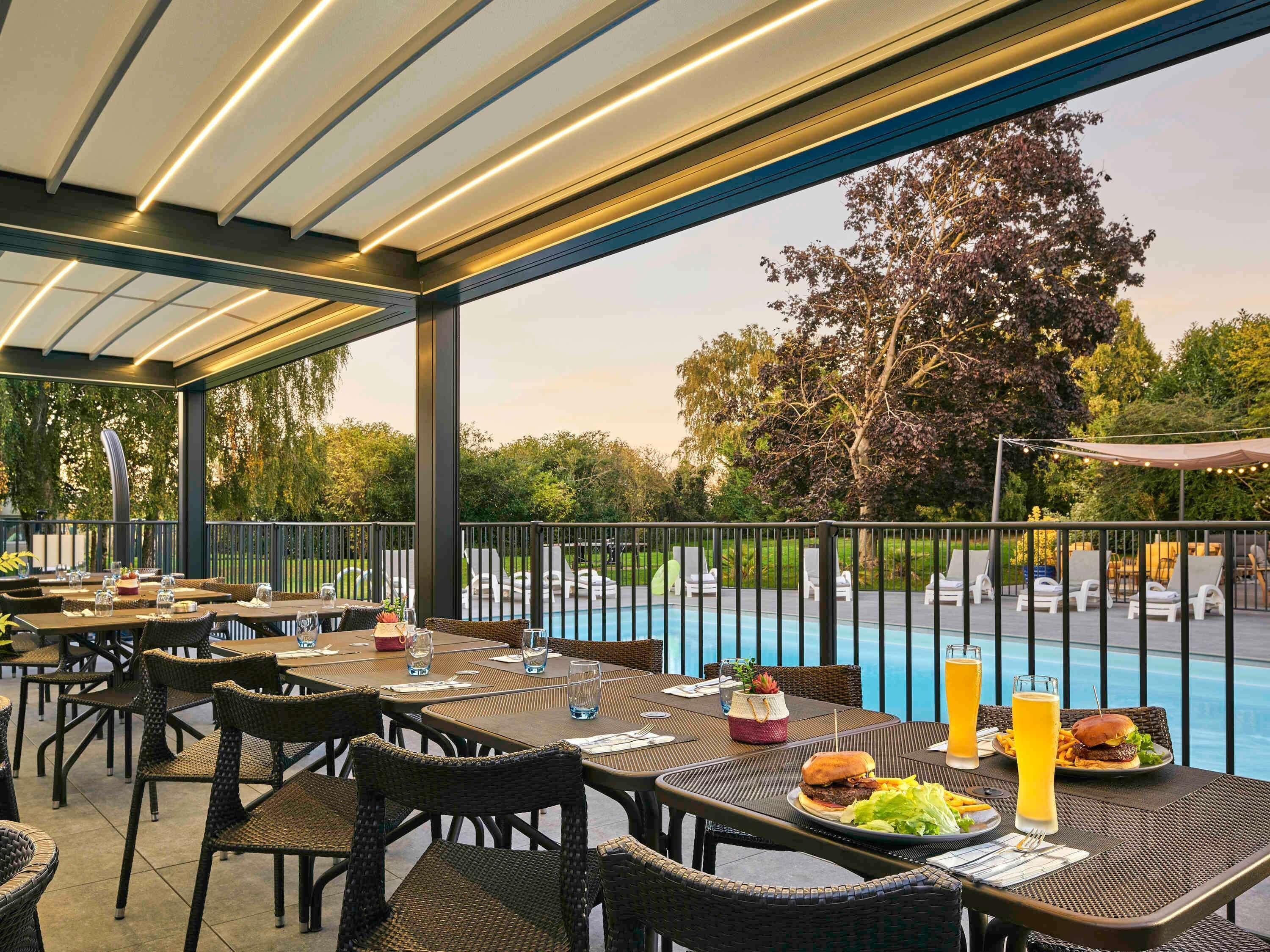 Una piscina al aire libre, sillones reclinables de piscina