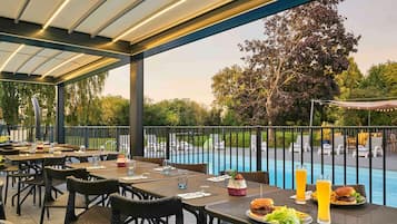 Una piscina al aire libre, sillones reclinables de piscina