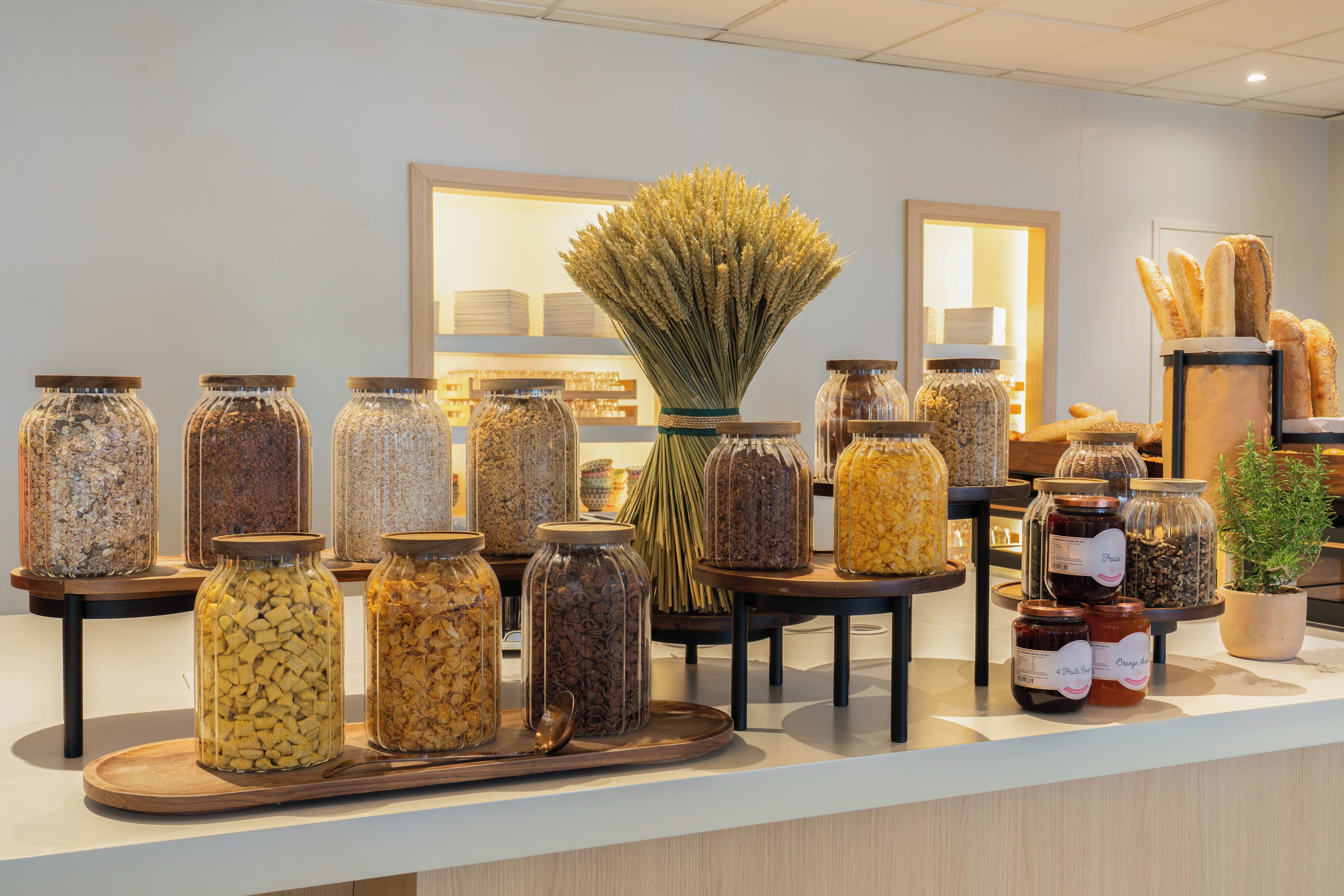 A display of various food items in glass jars on a counter.