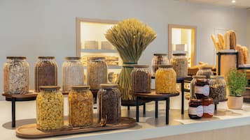 A display of various food items in glass jars on a counter.