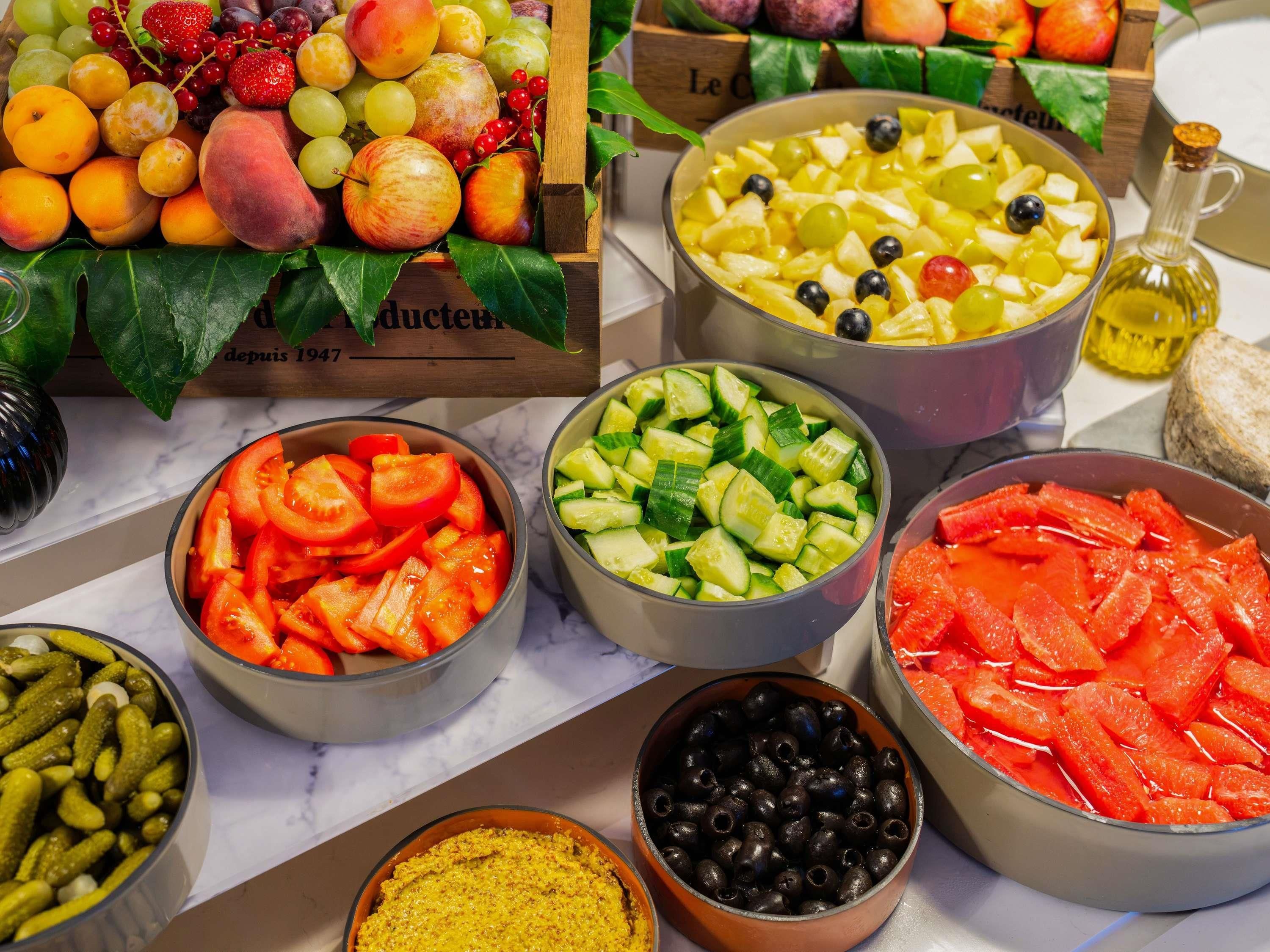 A variety of food items including fruits, vegetables, and olives arranged on a table.