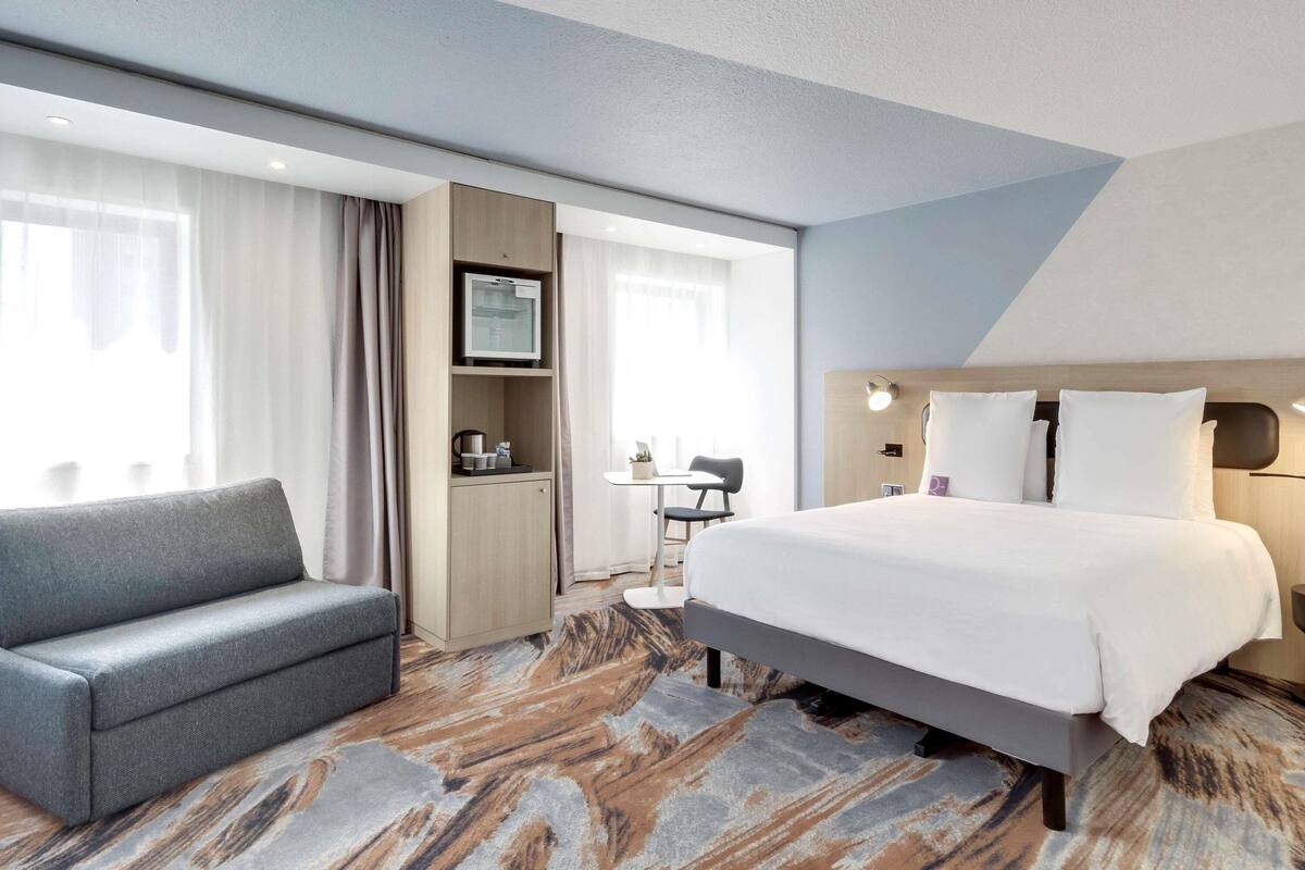 Une chambre d’hôtel équipée d’un lit, d’un canapé, d’un bureau et d’une télévision.