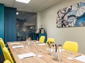 A conference room with a long table, yellow chairs, and glass vases with plants. - Mercure Paris Gare De Lyon TGV (Paris)