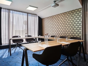 A conference room with a long table, chairs, and a projector.