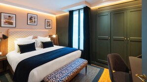 A hotel room with a large bed, a bench, a desk, and a wardrobe. - Le Stendhal - Vendôme (Paris)
