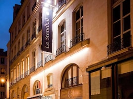 A building with a sign reading "Le Stendhal" and a logo indicating it is a hotel.