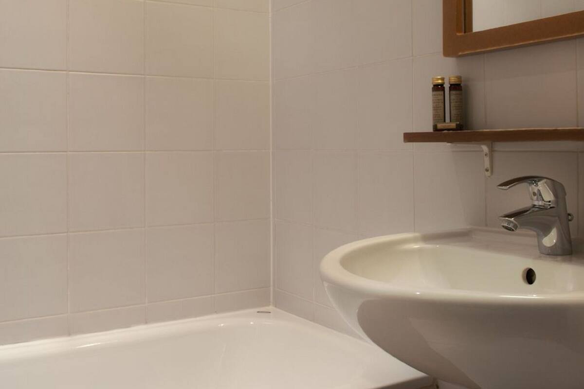 Ein Badezimmer mit einer weißen Badewanne, einem Waschbecken und einem Spiegel.