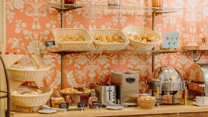 Un buffet de petit-déjeuner proposant un assortiment de pains et de viennoiseries, une machine à café et un grille-pain.