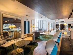 A hotel lobby with seating areas, a bar, and a reception desk. - Aigle Noir Hotel Fontainebleau -  MGallery Collection (Fontainebleau)