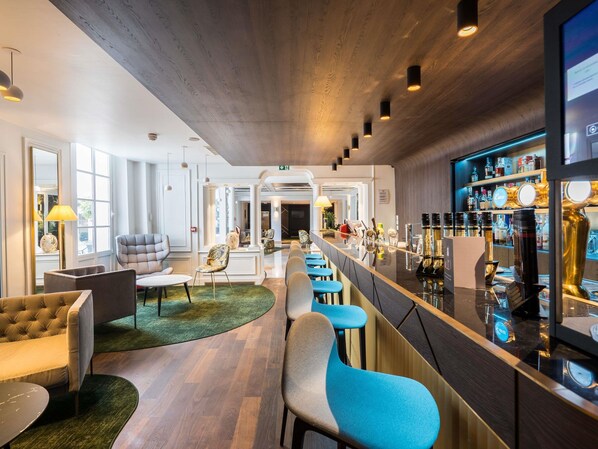 A modern bar area with a long counter, bar stools, and a variety of bottles. - Aigle Noir Hotel Fontainebleau -  MGallery Collection (Fontainebleau)
