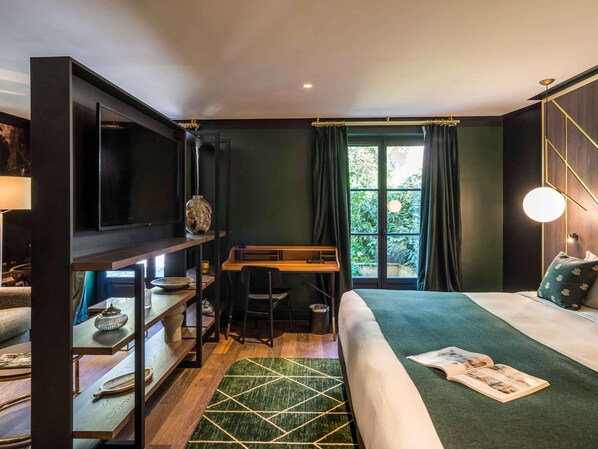 A modern room with a bed, a desk, and a TV.
