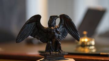 Une statue d’aigle en bronze, posée sur un piédestal.