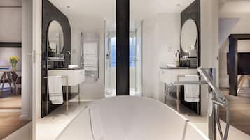 Un baño moderno con una bañera grande, dos lavamanos y una cabina de ducha de vidrio.
