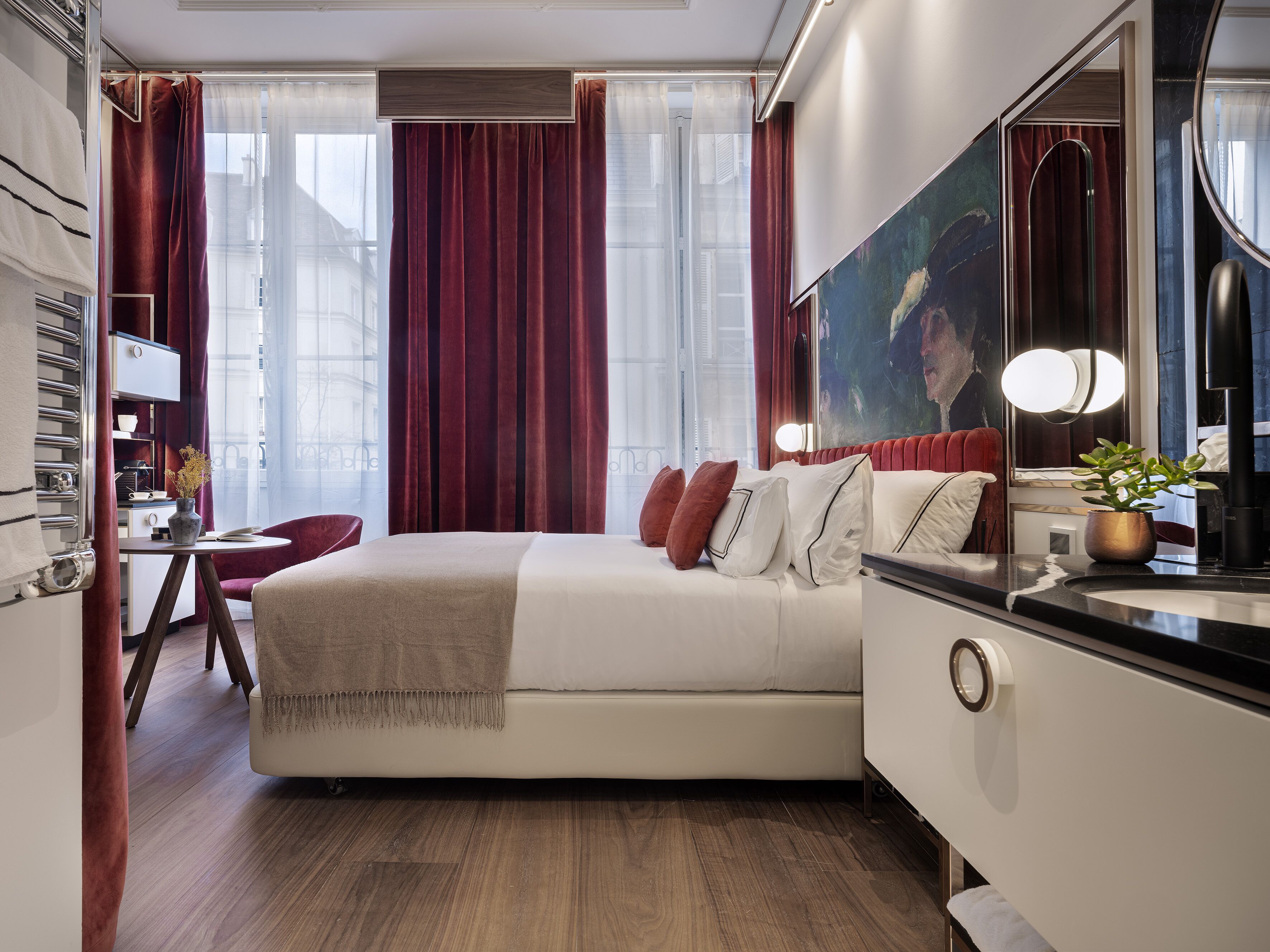 Una habitación de hotel moderna con una cama grande, un escritorio y un espejo amplio.
