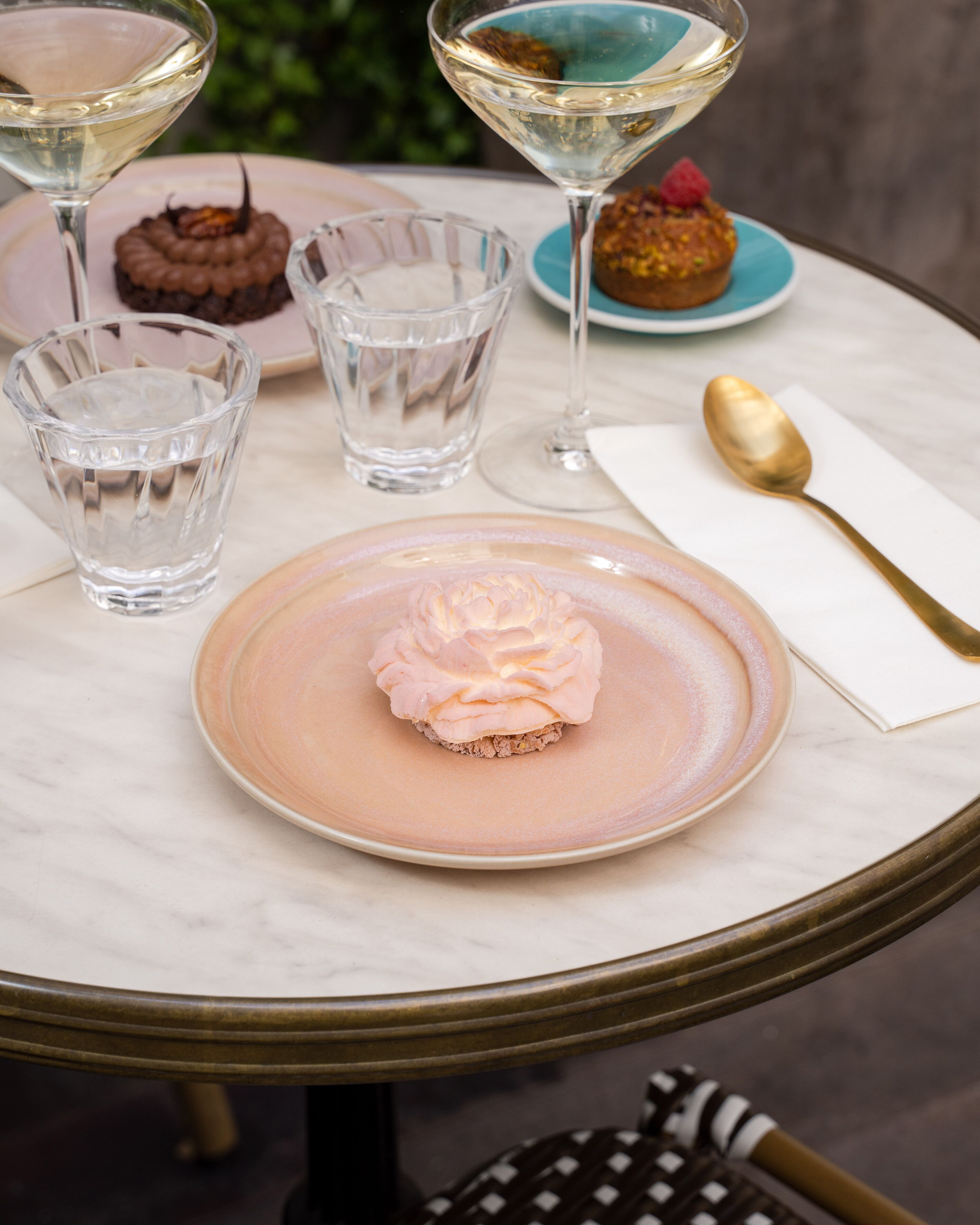 A table with a dessert plate, two glasses of water, and a dessert on a plate.