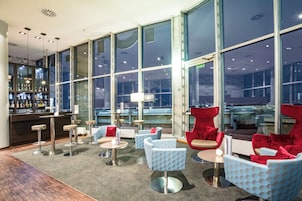 Una zona lounge moderna con posti a sedere, un bar e ampie finestre.