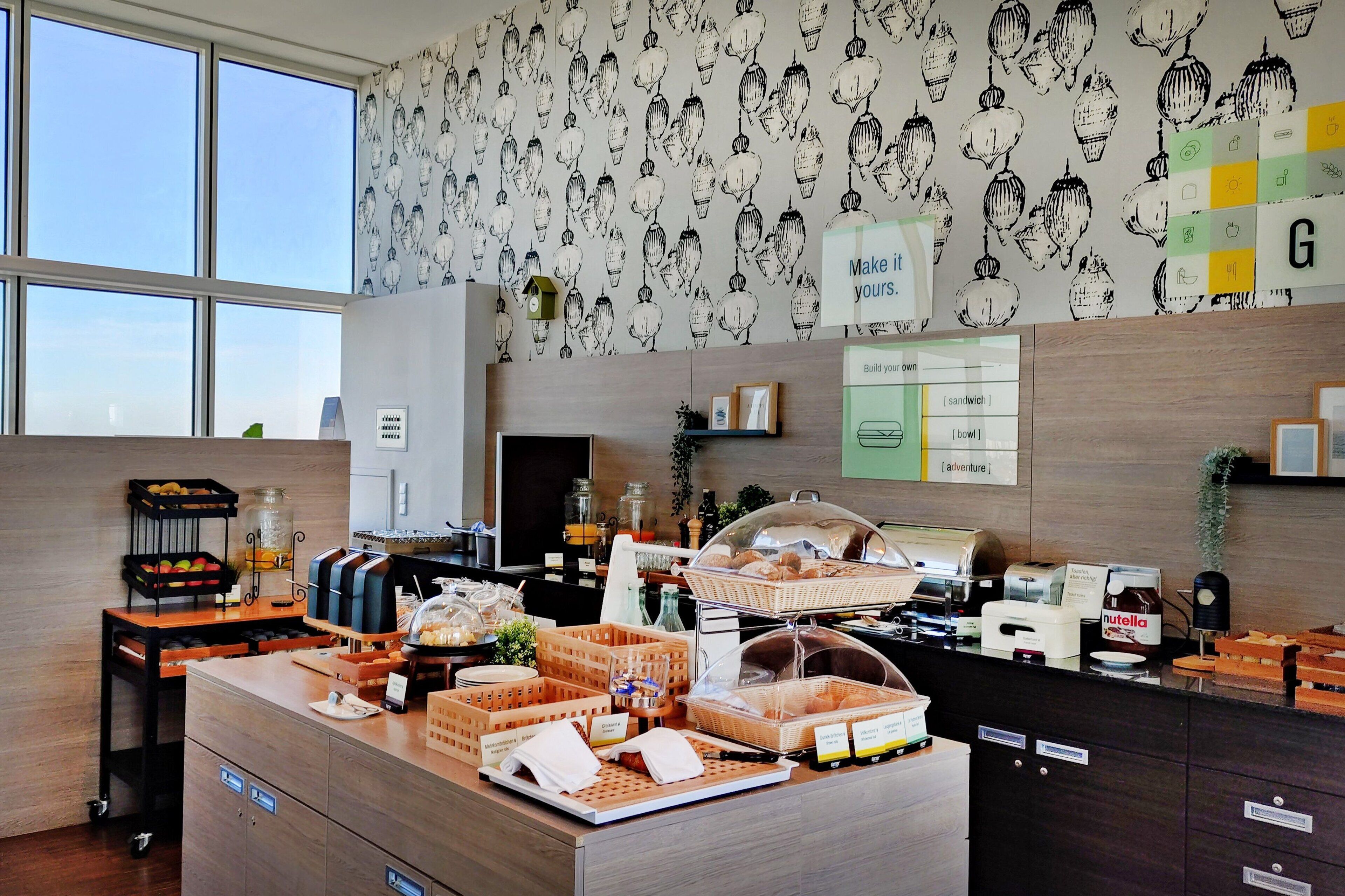 A breakfast area with a variety of food items and a sign that says "Make it yours."