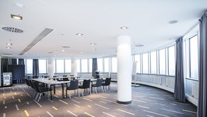 A conference room with a long table, chairs, and a large pillar.