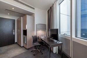 A modern hotel room with a desk, chair, and large window. - Garner Hotel Berlin - Spandau by IHG (Berlin)